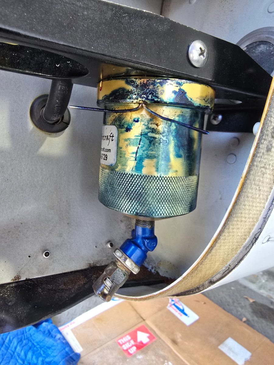 Improperly installed aftermarket fuel screen with non-structural screws, actively leaking with blue fuel stains